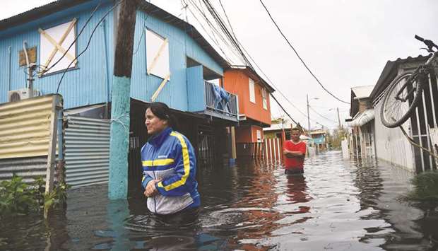 People walk across a flooded street in Juana Matos, Puerto Rico as the country faced dangerous flooding and an island-wide power outage following Hurricane Maria.