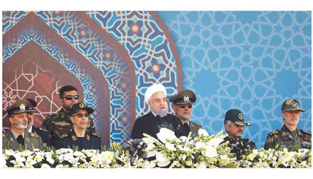 Iranian President Hassan Rouhani sits among senior army staff as he delivers his speech during the annual military parade marking the anniversary of the outbreak of its devastating 1980-1988 war with Saddam Husseinu2019s Iraq, in Tehran, yesterday.