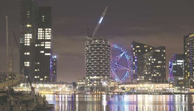 The Melbourne Star observation wheel is seen between residential buildings at night in the Docklands area of Melbourne. Policy makers are seizing on public resentment and hitting foreign buyers with more taxes on u2018ghost towersu2019 in Australia.