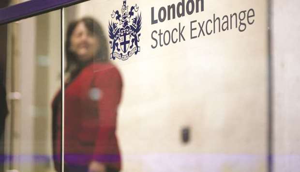 A visitor passes a sign inside the London Stock Exchange. The FTSE 100 closed up 0.6% to 7,310.64 points yesterday.