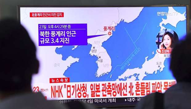 People watch a television news showing a map of the epicenter of an earthquake in North Korea