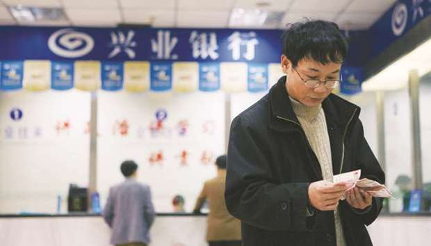 A customer counts his yuan notes at a branch of Industrial Bank in Shanghai. Fund managers have raised 95.8bn yuan ($14.54bn) this year through late September in funds denominated in the Chinese currency compared with 56.7bn yuan in all of 2016.