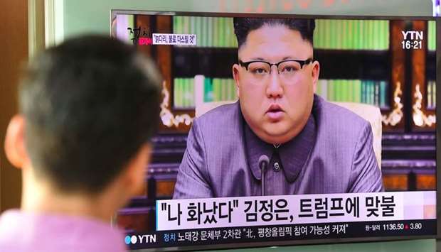 A man watches a television news screen showing a picture of North Korean leader Kim Jong-Un