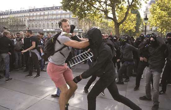 A demonstrator tries to prevent a group of balaclava-clad people from trying to take over a stage platform during a protest in Paris yesterday against the French governmentu2019s labour reforms.