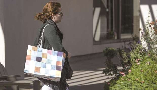 A pedestrian carries a shopping bag in Corte Madera, California (file). Federal Reserve officials said thereu2019s room to be patient in the run-up to their December policy meeting, even as they aired varying degrees of concern over this yearu2019s inflation slowdown.