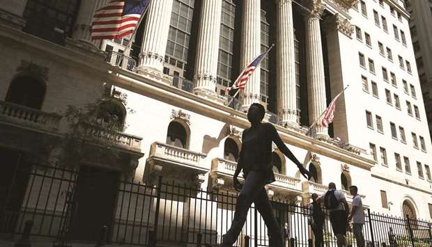 People walk by the New York Stock Exchange. A long stretch of low volatility for US stocks has made betting on continued calm a popular and lucrative trade, but traders warn that risks to the trade have mounted, while the potential for profits has shrunk.