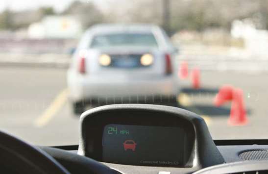 A red icon is displayed on a dashboard monitor indicating an impending collision with a stopped vehicle at a demonstration of General Motoru2019s vehicle-to-vehicle communication system in East Rutherford, New Jersey on March 21, 2007. Vehicle-to-vehicle communication systems, known as V2V, are regarded as essential for fully automated travel, which could dramatically reduce traffic fatalities from around 40,000 in the US last year.