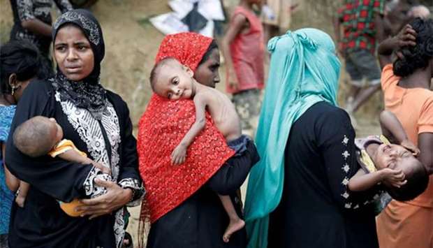 Rohingya refugees wait to receive aid in Cox's Bazar, Bangladesh.