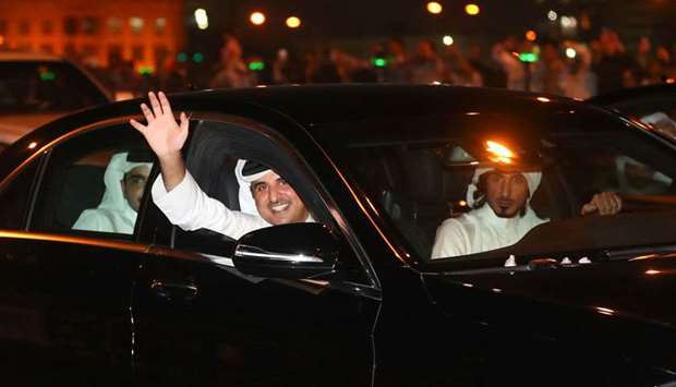 His Highness the Emir Sheikh Tamim bin Hamad al-Thani waves at the welcoming citizens and residents lined up along the Doha corniche.