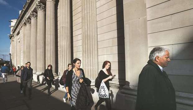 Pedestrians walk past columns of the Bank of England building in London. British consumer borrowing is growing at nearly 10% a year, far faster than incomes, and the BoEu2019s Financial Policy Committee said it would tell banks by the end of the year how much extra capital to hold, based on the riskiness of their lending.