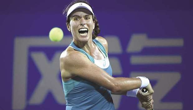 Johanna Konta of Great Britain hits a return against Ashleigh Barty of Australia during their first round match at the WTA Wuhan Open in Wuhan yesterday. (AFP)