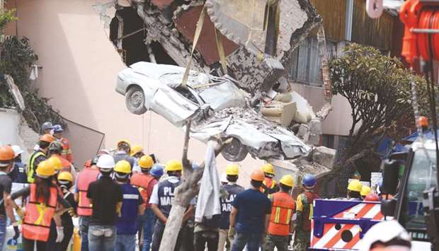 A flattened car is extracted from the rubble of a collapsed building in the Roma Norte neighbourhood in Mexico City.