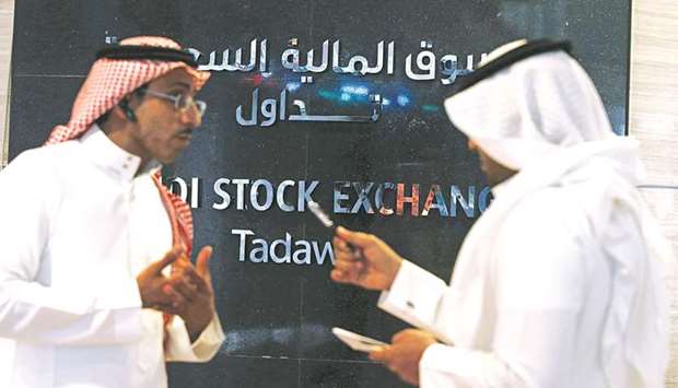 Traders talk at the Saudi Stock Exchange (Tadawul) in Riyadh (file). Two fund managers told Reuters that the Saudi stock index fell 1.4% yesterday because investors were worried that FTSE might delay the upgrade on the grounds that foreign investors lacked enough access.