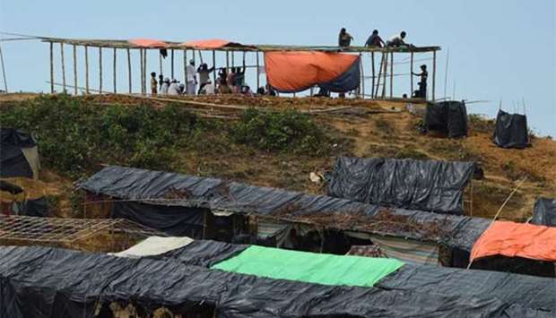 Rohingya refugees erecting a shelter at a camp in Bangladesh's Ukhia district.