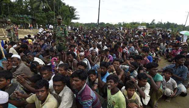 Rohingya Muslim refugees wait for food to be distributed by the Bangladeshi army at Balukhali refugee camp near Gumdhum
