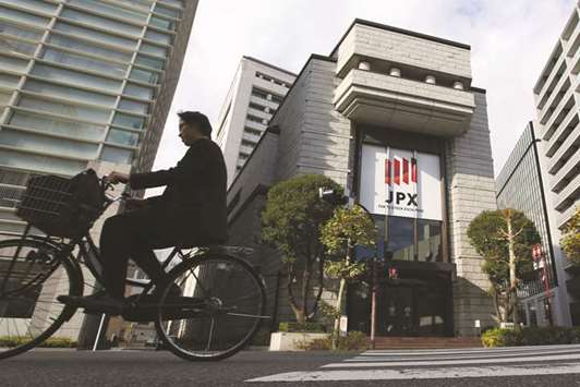 A man cycles past the Tokyo Stock Exchange. State Street Corpu2019s asset management unit is bullish on stocks, especially those in Japan.