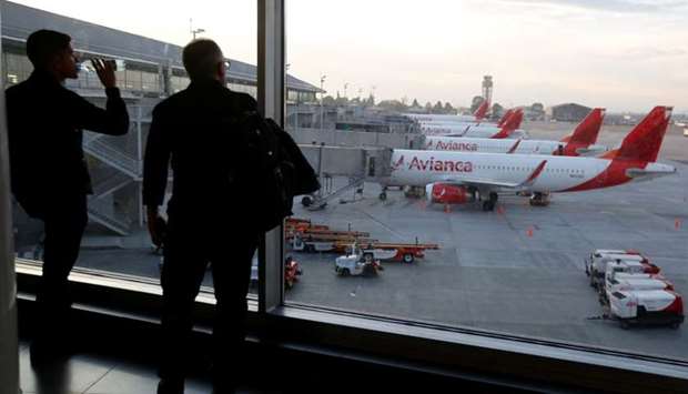 Passengers look at aircraft of Colombian airlines Avianca as the airline's flights are cancelled due to a pilots strike, at El Dorado airport in Bogota, Colombia