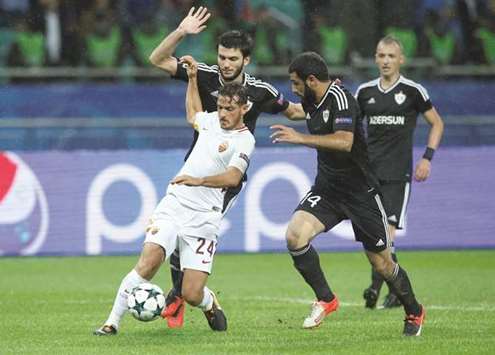 AS Romau2019s Alessandro Florenzi (left) and Qarabagu2019s Rashad Sadygov battle for the ball during the UEFA Champions League match at Olympic Stadium in Baku, Azerbaijan, yesterday. (Reuters)