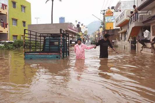 Men wade through a street after heavy rains in Mysuru yesterday.
