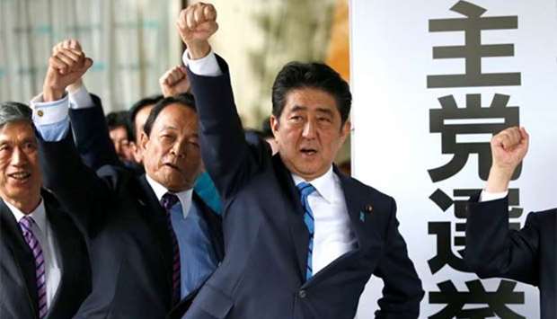 Japan's Prime Minister Shinzo Abe and his party's lawmakers raise their fists as they pledge to win the upcoming lower house election, at their party headquarters in Tokyo on Thursday.