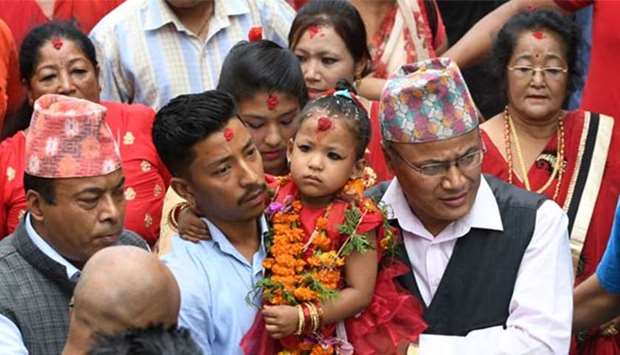 Trishna Shakya, 3, is carried by her father Bijaya Ratna Shakya as she heads to Kumari House in Kathmandu on Thursday.
