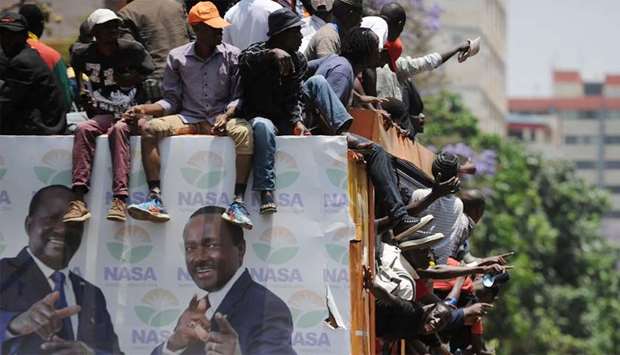 Protestors chant on the back of a campaign truck bearing the images of Kenya's opposition coalition National Super Allinace (NASA) flag bearer and runnimg mate, Raila Odinga and Stephen Kalonzo