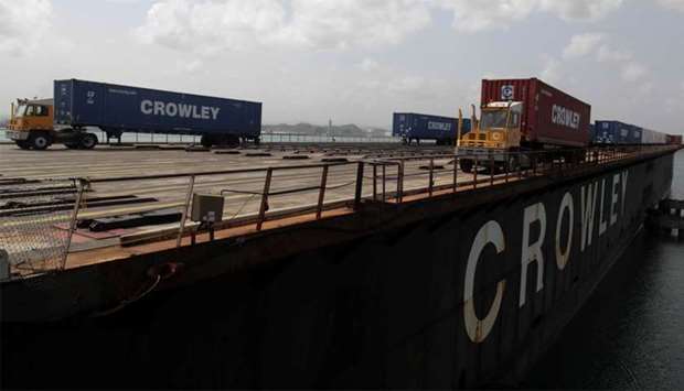 Workers unload containers of shipping company Crowley from a barge after the area was hit by Hurricane Maria at the port in San Juan