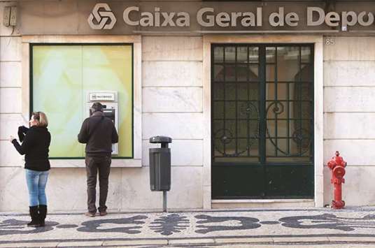 A customer uses an ATM outside a Caixa Geral de Depositos branch in Lisbon. State-owned Caixa, as well as Novo Banco and Millennium bcp, will set up a private platform to manage loans that at least two of them have made to the same corporate borrowers, Deputy Finance Minister Ricardo Mourinho Felix said.