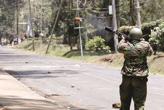 A riot police officer fires a teargas canister to disperse University of Nairobi students protesting against the detention of an opposition legislator in Nairobi.
