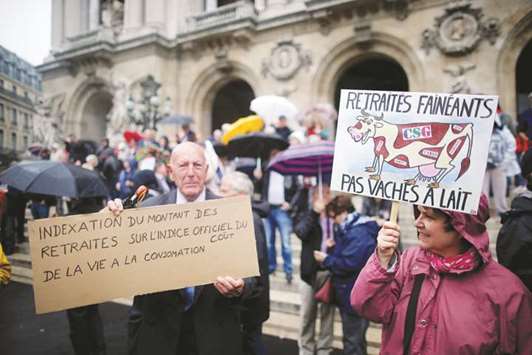 Pensioners protest government reforms in Paris. The placard on the right reads, u2018Lazy pensioners, but not cash cowsu2019.