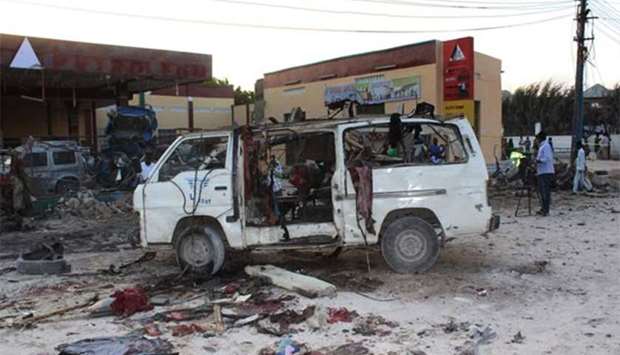 Bystanders look at the wreckage of a minibus after a car bomb exploded in the centre of Mogadishu on Thursday. At least seven people were killed and several others wounded after a car bomb exploded near a marketplace in Mogadishu, a city official said.