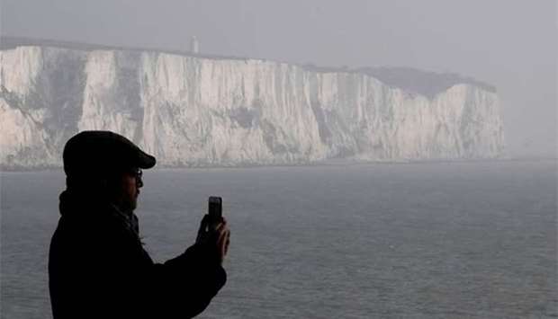 A passenger views the White Cliffs of Dover, the closest British coastline to mainland Europe, from a cross-channel ferry between Dover in Britain and Calais in France.