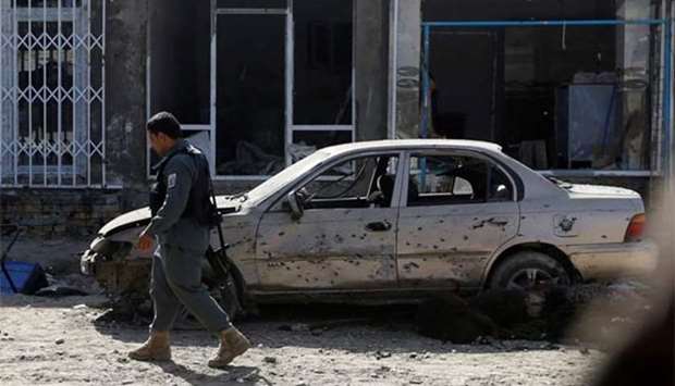 An Afghan policeman inspects the site of a suicide attack in Kabul on Friday.