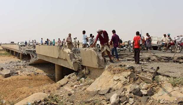 People look at the damage on a bridge hit by a Saudi-led air strike near the northwestern city of Harad, Yemen September 23, 2017