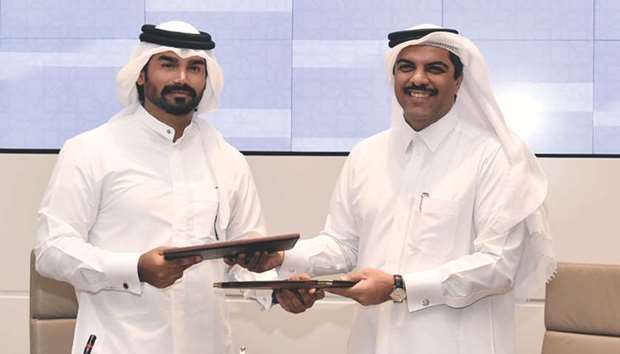 Dr Khalid al-Khanji and Emad al-Khaja exchange papers after signing the MoU yesterday.