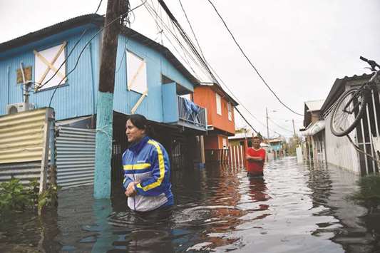 People walk across a flooded street in Juana Matos, Puerto Rico, following Hurricane Maria.
