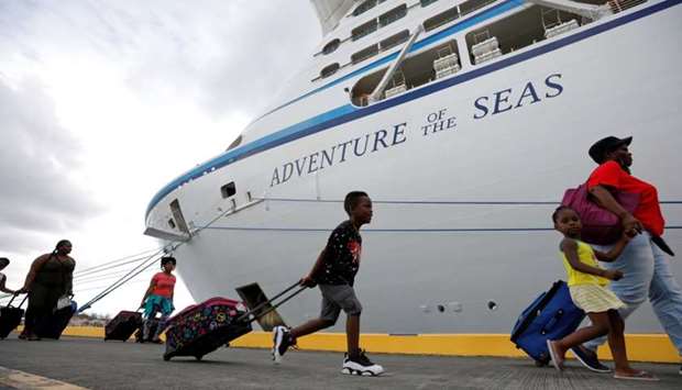 A family carries their luggage to Royal Caribbean's Adventure of the Seas, a mercy ship that took evacuees from the island who were fleeing the aftermath of Hurricane Maria, in Frederiksted, St. Croix, US Virgin Islands.