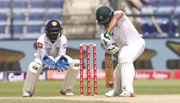 Pakistani batsman Azhar Ali plays a shot as Sri Lankan wicket-keeper Niroshan Dickwella looks on during the third day of the first Test at Sheikh Zayed Stadium in Abu Dhabi yesterday. (AFP)