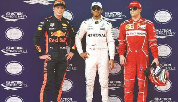 Mercedesu2019 British driver Lewis Hamilton (centre) celebrates taking pole position next to second fastest Ferrariu2019s Finland driver Kimi Raikkonen (right) and third fastest Red Bullu2019s Dutch driver Max Verstappen after the qualifying session of the Malaysia GP in Sepang yesterday. (AFP)