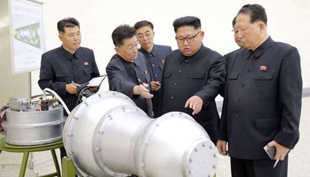 North Korean leader Kim Jong-Un (centre) is looking at a metal casing with two bulges at an undisclosed location. North Korea has developed a hydrogen bomb.