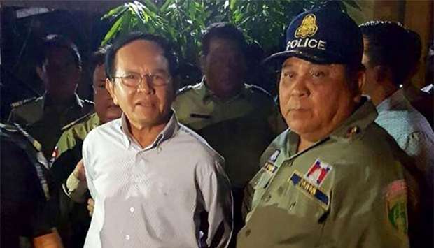 Cambodian opposition leader Kem Sokha is escorted by police at his home in Phnom Penh on Sunday.