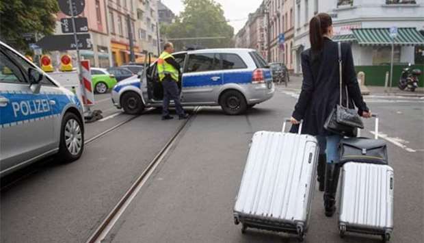 A woman pulls suitcases as she leaves her apartment following an evacuation in Frankfurt am Main, western Germany, on Sunday.