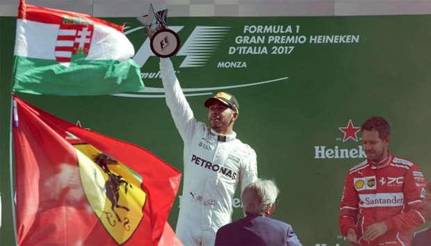 Mercedes' Lewis Hamilton celebrates winning the race with the trophy