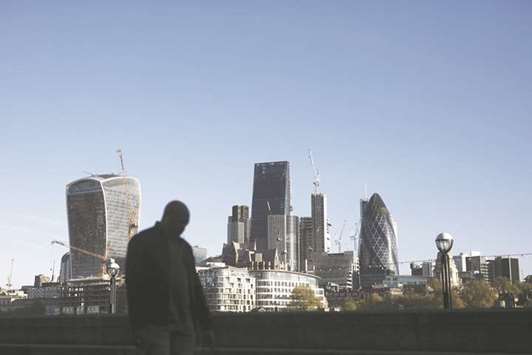 A pedestrian passes by as skyscrapers stand beyond, in London. AustralianSuper, which has A$120bn ($95bn) in assets, is looking to invest more overseas, with real estate and infrastructure in the UK, Europe and the US.