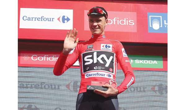 Overall leader Skyu2019s British cyclist Christopher Froome waves as he celebrates his red jersey on the podium for the 15th stage of the Vuelta a Espana in Alto Hoya de la Mora, Spain, yesterday. (AFP)