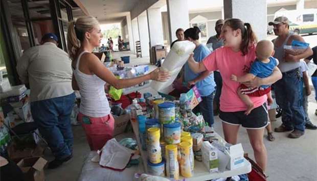 Tiffany Quillen (left) helps to distribute relief supplies that she and a group of friends brought from North Carolina to flood victims, in Orange, Texas.