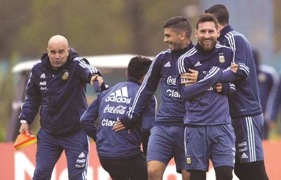 Argentinau2019s Lionel Messi (second right), Ever Banega (centre) and Angel Di Maria joke around during a training session in Ezeiza, Buenos Aires on Sunday, ahead of their FIFA World Cup qualifier match against Venezuela. (AFP)