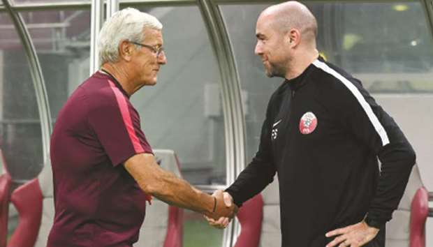 Chinau2019s coach Marcello Lippi (L) with his Qatar counterpart Felix Sanchez in Doha yesterday.