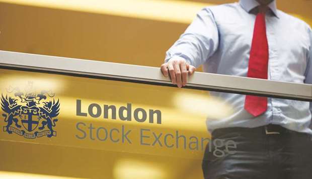 An employee leans on a glass wall above the main atrium of the London Stock Exchange Group headquarters. London stocks slid 0.4% at 7,411.47 points yesterday.