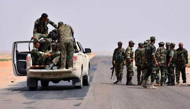 Syrian pro-government forces are seen on a road in Bir Qabaqib, more than 40 kilometres west of Deir Ezzor, on Monday.